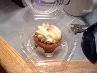Picture of a carrot cake cupcake with cream cheese frosting.