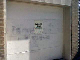 A sunfaded sign, reading: (blank) parking only, unauthorized vehicles will be (blank) at owners expense.